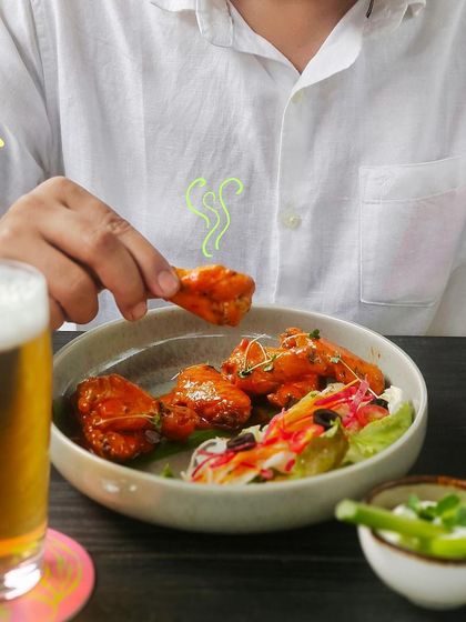 A perfect pairing of spicy buffalo chicken wings and a cold glass of beer.