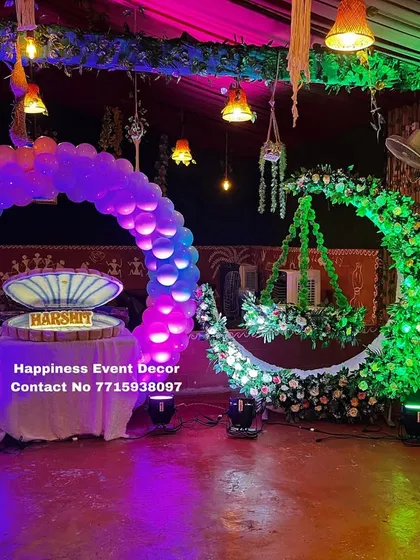 Here is a vibrant naming ceremony setup with a fun theme. It includes a balloon ring backdrop for the name reveal, a floral crescent moon with a hanging cradle, and cutouts of Lord Krishna, all brought together with colorful lighting.