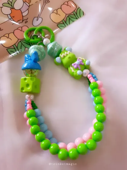 A vibrant green and pink beaded charm with fun, quirky beads, including a little blue bunny. This one is for those who love a playful and colorful accessory.