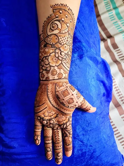This gorgeous engagement henna was for my teacher. It features a prominent peacock on the arm, with a mix of floral and grid patterns on the hand.