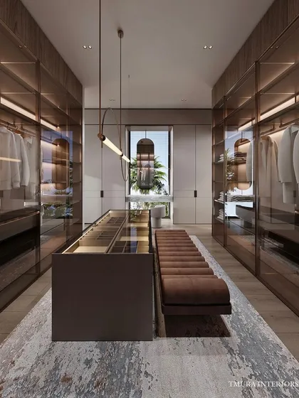 This is our vision of a modern walk-in wardrobe. More than just storage, it is a meticulously organized personal gallery, featuring integrated LED lighting, glass-fronted cabinets, and a central island with bespoke compartments for accessories.