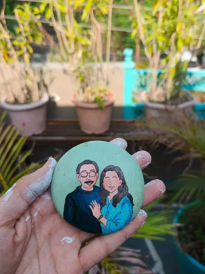 A hand-painted stone portrait of a couple. Our workshops encourage all forms of creativity, including unique keepsakes like this.