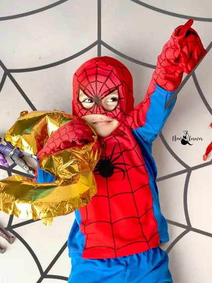 Our little Spider-Man celebrating his third birthday with a web-slinging pose. The dynamic overhead shot adds to the excitement.