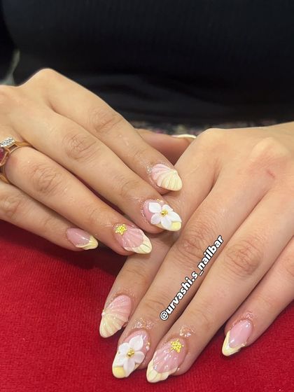 This elegant set features sculpted shell textures on the tips and hand-crafted 3D florals with tiny gold accents. The combination of textures on a soft blush base creates a truly sophisticated and artistic look.