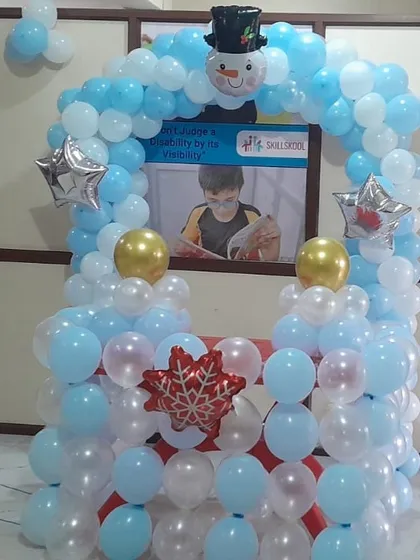 A winter-themed balloon stall created for a school event. The blue and white balloons, along with snowman and snowflake foil balloons, create a festive and fun photo or activity booth.