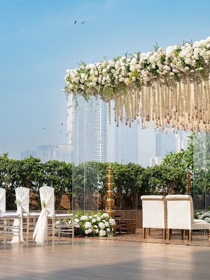 The mandap set against the Mumbai skyline, showing how we integrate urban backdrops with elegant decor. The transparent pillars ensure the city view remains a part of the scenic design.