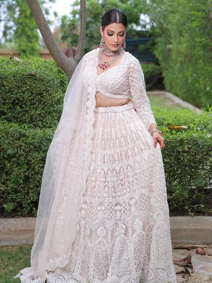 A model in an elegant white outfit, showing how my henna designs can be a subtle yet stunning accessory for any party or reception.