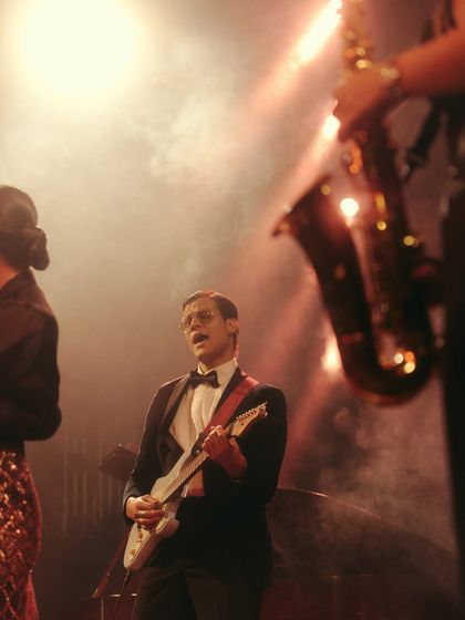 The guitarist, styled in a classic tuxedo, is captured in his element. Casting real musicians and performers adds a layer of authenticity to the campaign's story.