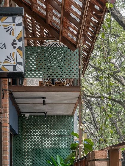 The exterior signage and balcony of Klaa Kitchen. The hand-painted tile sign and traditional roof details immediately signal the Goan inspiration behind the design.