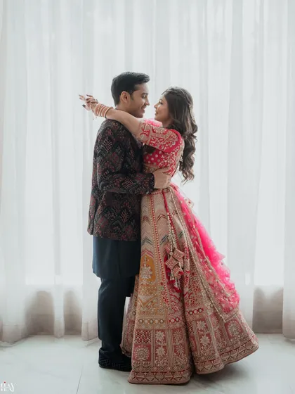 A joyful and romantic embrace. The bride's arms are wrapped around the groom, and their shared look of happiness makes this a heartwarming and genuine couple portrait.