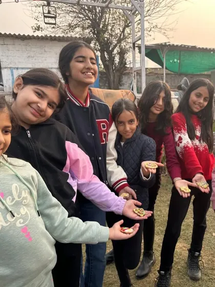 A group of proud kids showing off their beautifully decorated Christmas cookies.