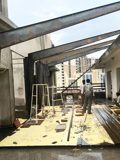 Another view of a steel roof structure under construction. The heavy I-beams create a powerful rhythm against the sky, demonstrating the potential of steel to create lightweight, expansive structures that can shelter outdoor spaces.