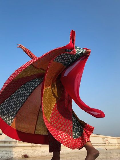 The costume itself becomes a dynamic part of the dance in this photo, as the fabric flies up in a spectacular display of color and movement.