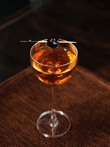 A closer look at our Forest cocktail, where aged whisky meets the unexpected notes of pinewood tea and green apple. Garnished with a single dark cherry, it is a sophisticated drink for the discerning palate.