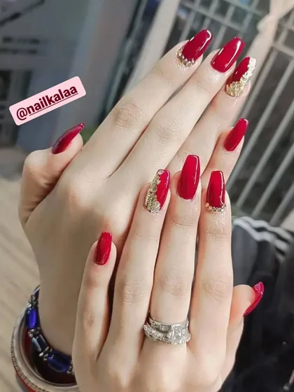 A bold and glamorous red set on long square nails. The accent nails feature a textured gold glitter design for a touch of luxury.