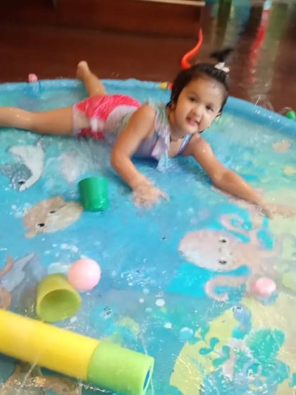 Pure happiness during our Holi party. This little girl is having a blast splashing around in the water play mat.