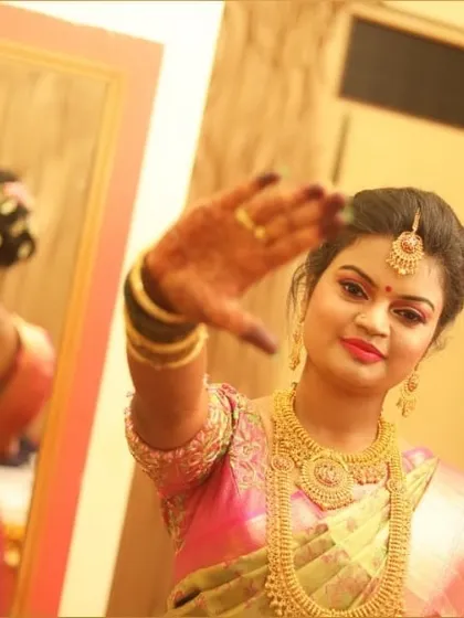 A playful pose from the bride, showing off her reception makeup. The look features bright, defined eyes and a bold lip color that matches the festive occasion.