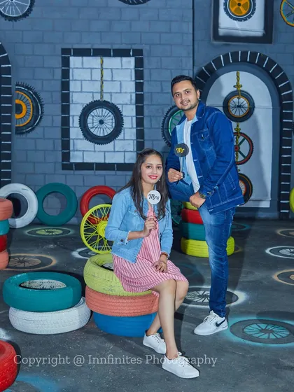For a quirky and modern vibe, we have this garage-themed set with colorful tires and industrial-style walls, perfect for couples in casual denim.