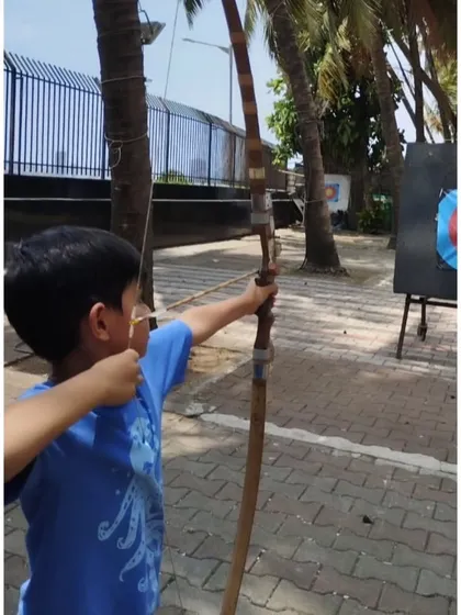 A young boy at our Dadar range, concentrating hard before his shot. This outdoor setting with palm trees is one of our most popular locations.