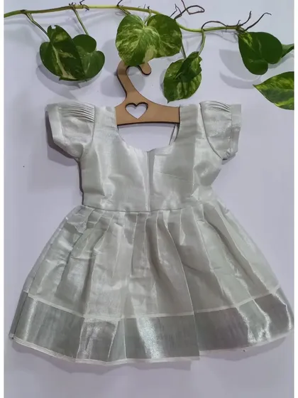 Just in time for Onam, this silver tissue dress is a delicate and beautiful piece. It has a soft cotton lining that gets softer with every wash and a little bow detail at the back.
