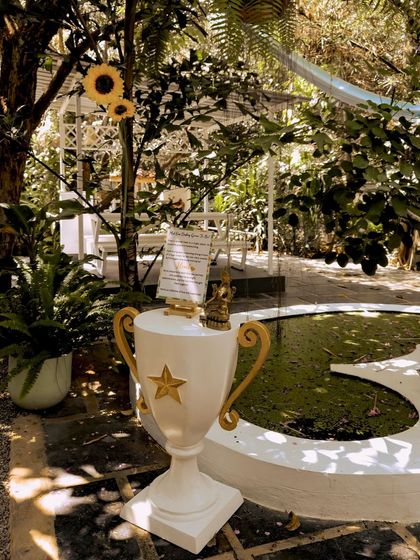 An "All About the Bride and Groom" corner at a Haldi ceremony, featuring a trophy and other personal items.