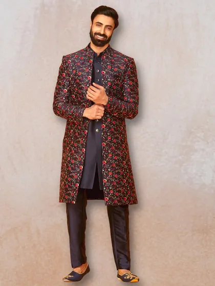 For a bold and memorable look, this dark sherwani with vibrant red floral embroidery is a fantastic choice. It's perfect for an evening reception or sangeet.