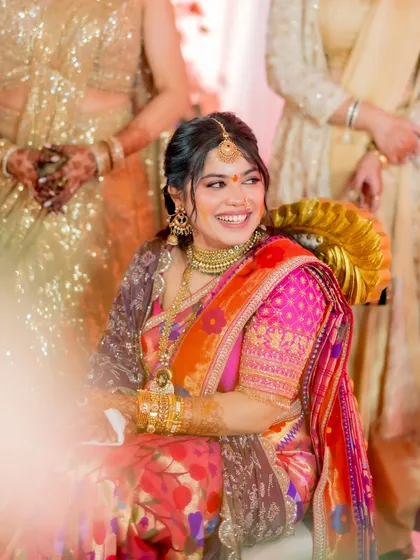 A happy, glowing bride surrounded by her loved ones. Her makeup is soft and timeless, enhancing her natural beauty during the engagement ceremony.