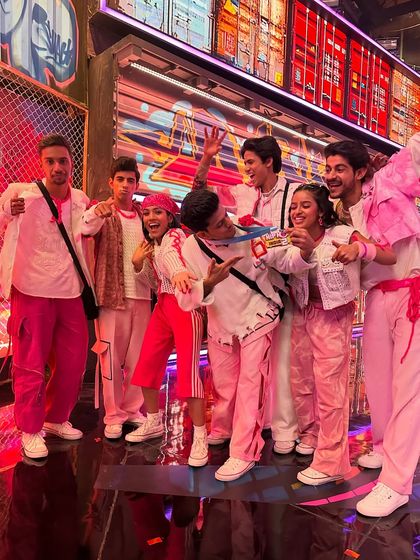 A fun, candid moment with my crew, The Evokers, on set. We were all dressed in pink for this particular theme, showcasing our coordinated look and team spirit.