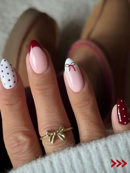A chic and minimalist Christmas design. This set features a mix of polka dots, a simple bow, and a classic red French tip for a festive yet sophisticated look.