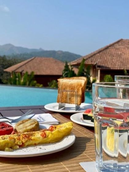 Breakfast by the pool with a view of the Sakleshpur hills. This is the kind of relaxed and scenic dining experience I look for in my curated stays.