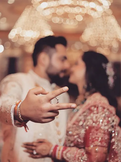 Sometimes, the most powerful stories are in the details. Here, the focus is on the ring, the symbol of your promise, with the couple softly blurred in a moment of closeness. The beautiful bokeh from the lights adds a dreamy, romantic feel that I love to create in my couple portraits.