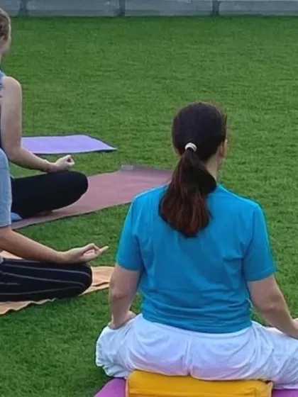 Students sit for meditation on the lush grass during our Dubai retreat. Practicing outdoors helps to ground our energy and connect with the earth.