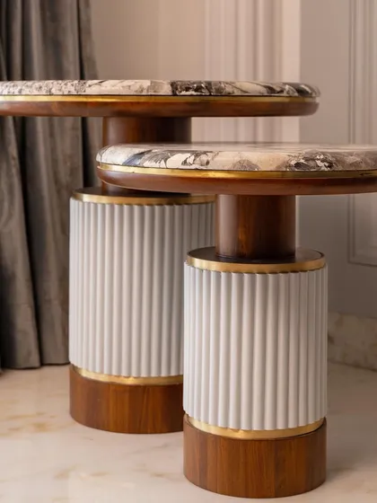 Another view of the custom side tables, showing their sculptural form and elegant material combination.