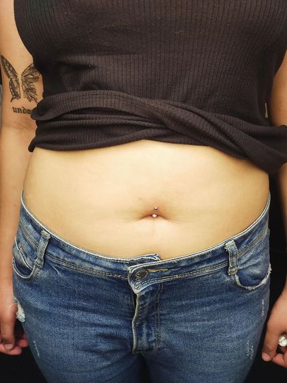 A minimalist navel piercing with a simple silver stud. This is a great option for a subtle yet stylish look.