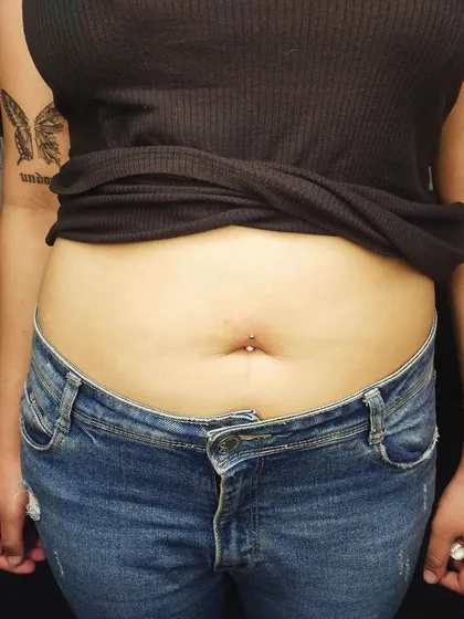 A minimalist navel piercing with a simple silver stud. This is a great option for a subtle yet stylish look.