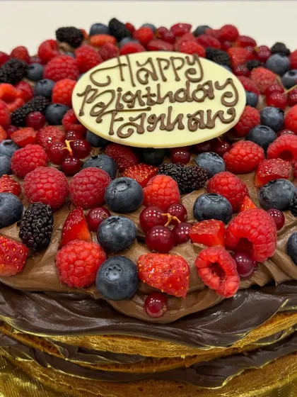 A birthday cake for Farhan Akhtar, featuring my layered chocolate cake topped with a mountain of fresh berries and a personalized chocolate plaque.