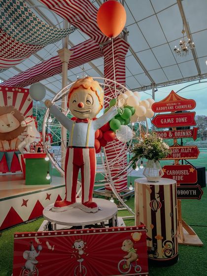 A cheerful, life-sized clown prop welcomes guests next to a directional sign pointing to the various fun zones. These signs help guide guests and build excitement for the different activities I've planned.