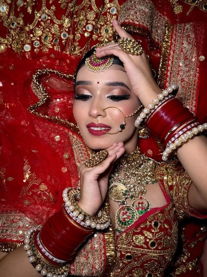 This pose highlights the intricate jewelry and the rich embroidery of the bridal lehenga. The makeup is kept classic to balance the heavy details of the outfit.