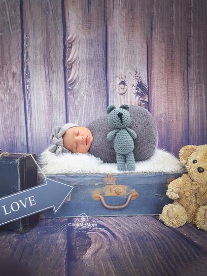 Another take on the traveler theme, this setup uses a rustic wooden backdrop and vintage props to create a timeless portrait of a little explorer.