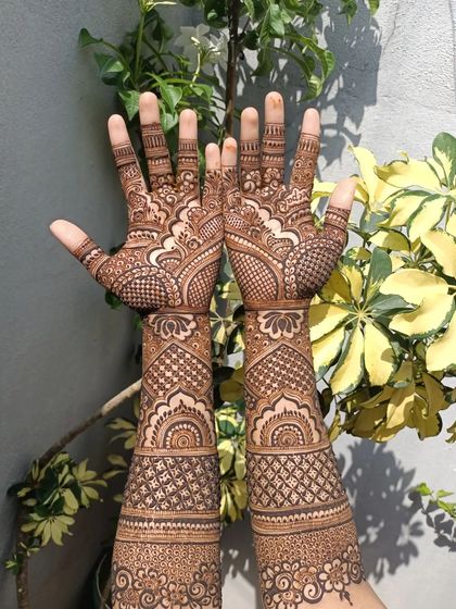 Full-arm bridal mehendi with a focus on geometric and architectural patterns. This style is perfect for brides who want a structured and modern yet traditional design.