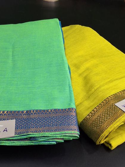 A selection of bright linen cotton dress materials. These fabrics in parrot green and lime yellow are perfect for stitching comfortable and vibrant summer outfits.