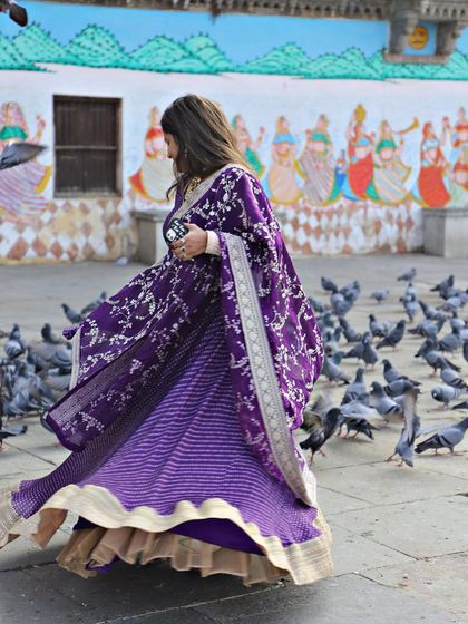 This purple bandhani-style lehenga is perfect for a pre-wedding shoot or event. The flowing fabric and rich color look stunning against any backdrop.