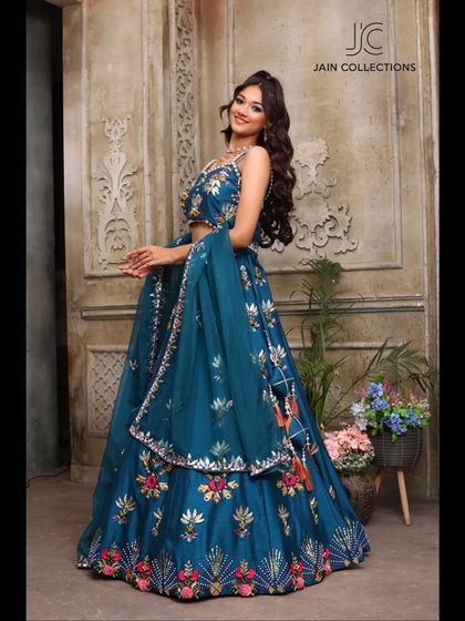 Make heads turn in this gorgeous teal floral lehenga. The bright colors and beautiful embroidery make it a standout piece for any celebration.