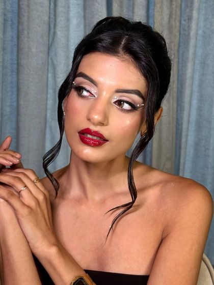 A different angle of this classic red lip look, showing the elegant updo and the flawless, glowing skin.