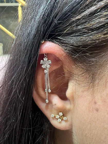 A long, cascading floral hanging creates a dramatic and beautiful effect, complemented by a simple gold stud.