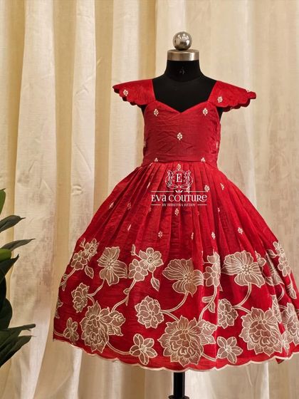 A stunning red frock with all-over white floral embroidery. The cap sleeves and scalloped hem give it a delicate, charming look.