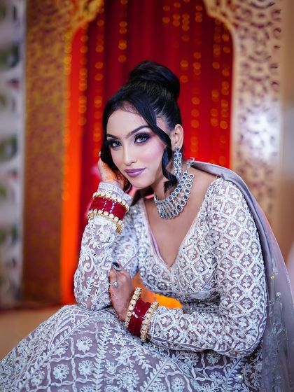 A seated pose that highlights the beautiful red bangles, adding a pop of color to the pastel look.