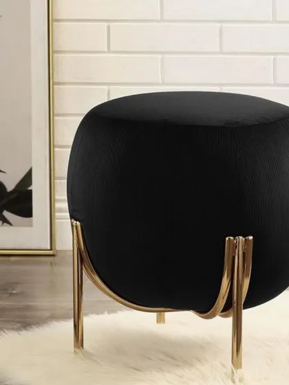How cute am I? A small, spherical ottoman in black velvet, held by a delicate, cradle-like gold metal frame. A perfect little jewel for any room.