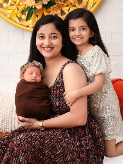 A mother and her two children. This heartwarming photo captures the loving embrace of a mother and her eldest daughter as they welcome the newest, tiniest member of their family.