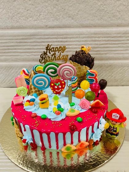 A vibrant "Candyland" cake, overflowing with lollipops, candies, and ice cream cones for a super sweet celebration.